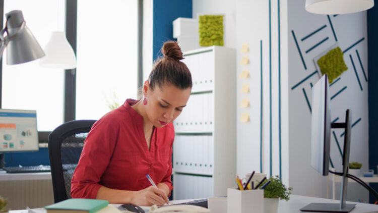 Woman organizing her desk as a grounding reset practice